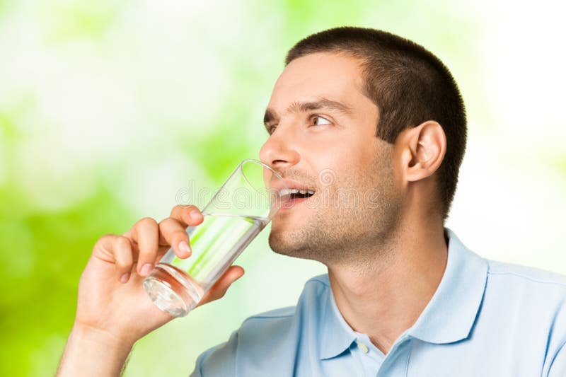 Young man with glass of water, outdoors. Young man with glass of water, outdoors