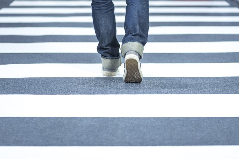 Man wear jeans walk across the street on the crosswalk royalty free stock photography Man wear jeans walk across the street on the crosswalk royalty free stock photography