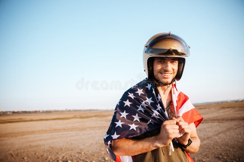 Man wearing american flag cape and golden looking at camera