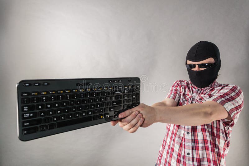 Man wearing balaclava shooting from keyboard royalty free stock photos