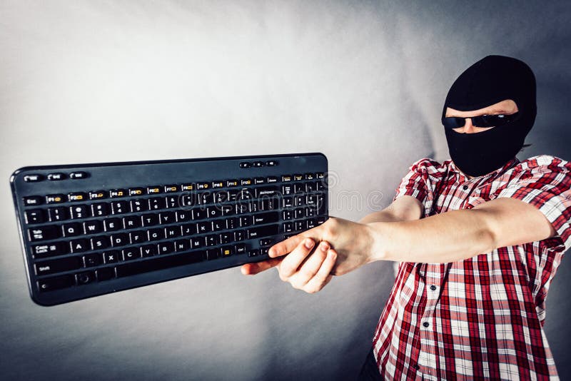 Man wearing balaclava shooting from keyboard royalty free stock photo