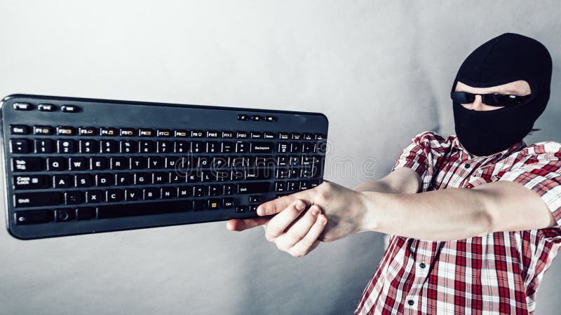 Man wearing balaclava shooting from keyboard stock photo