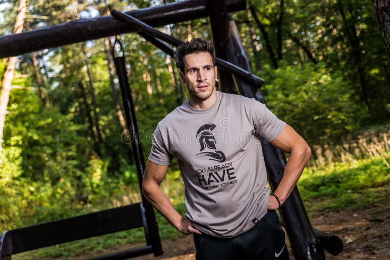 Man Wearing Brown Crew-neck T-shirt Standing Near Brown Wooden Swing at Daytime royalty free stock photo Man Wearing Brown Crew-neck T-shirt Standing Near Brown Wooden Swing at Daytime royalty free stock photo