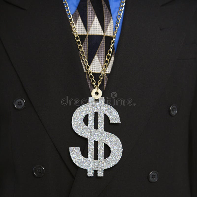 Man in suit wearing necklace with money sign. Man in suit wearing necklace with money sign.