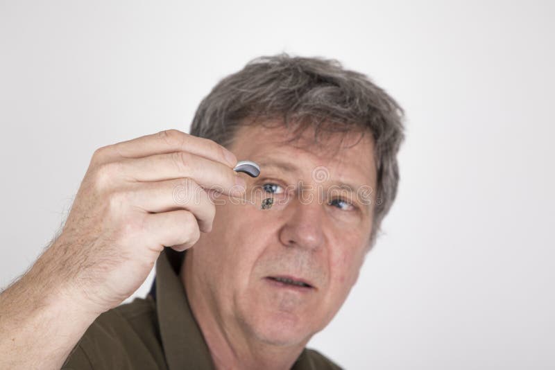 Man Wears a Hearing Aid and Places it in the Ear Stock Photo Image of
