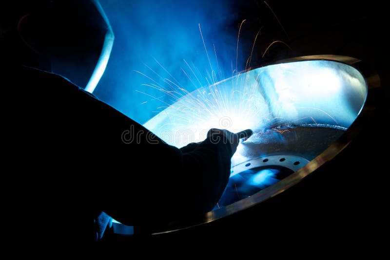 Welding a large metal wheel in a factory