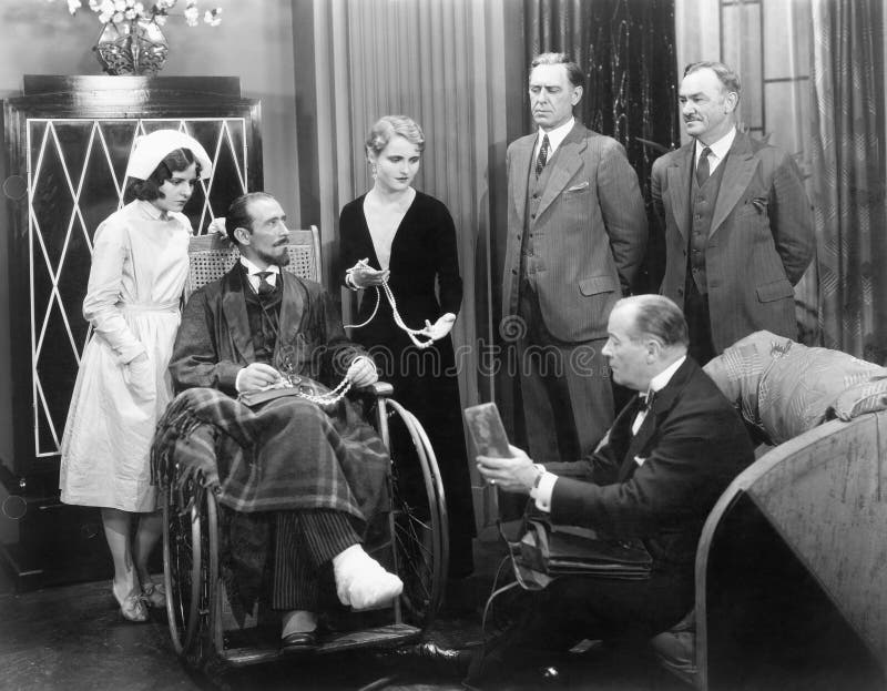 Man in a wheel chair with a broken foot and a group of people (All persons depicted are no longer living and no estate exists. Supplier grants that there will be no model release issues.)