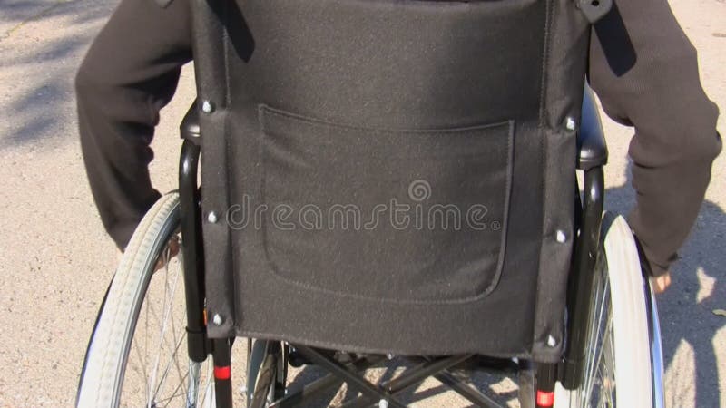 Man in a wheelchair rear view stock video