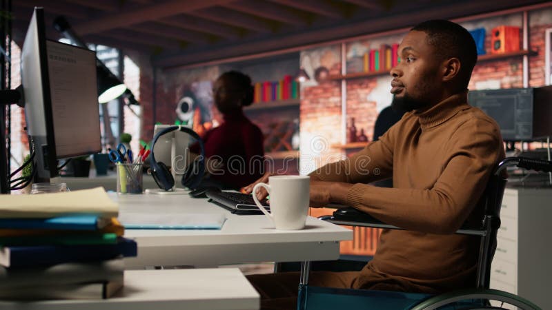 Man in wheelchair working in inclusive AI tech agency stock video footage