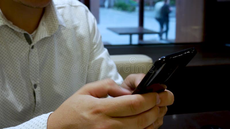 Man In White Shirt Chats On Black Phone