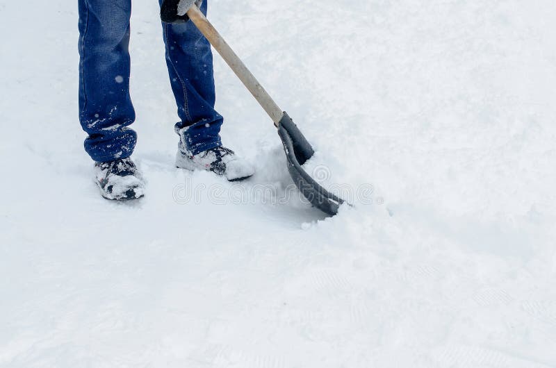 Man in Winter Clothes Clearing Snow from Path with Shovel. Winter Time