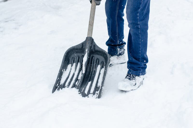 Man in Winter Clothes Clearing Snow from Path with Shovel. Winter Time