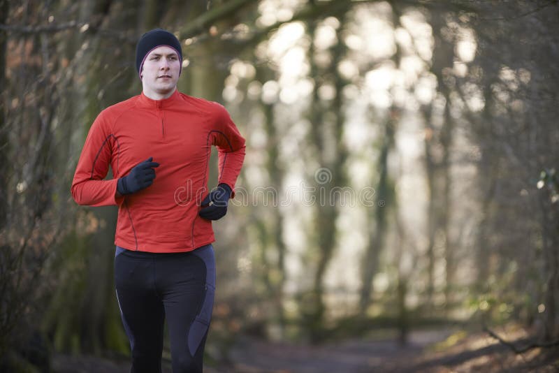 Man On Winter Run Through Woodland