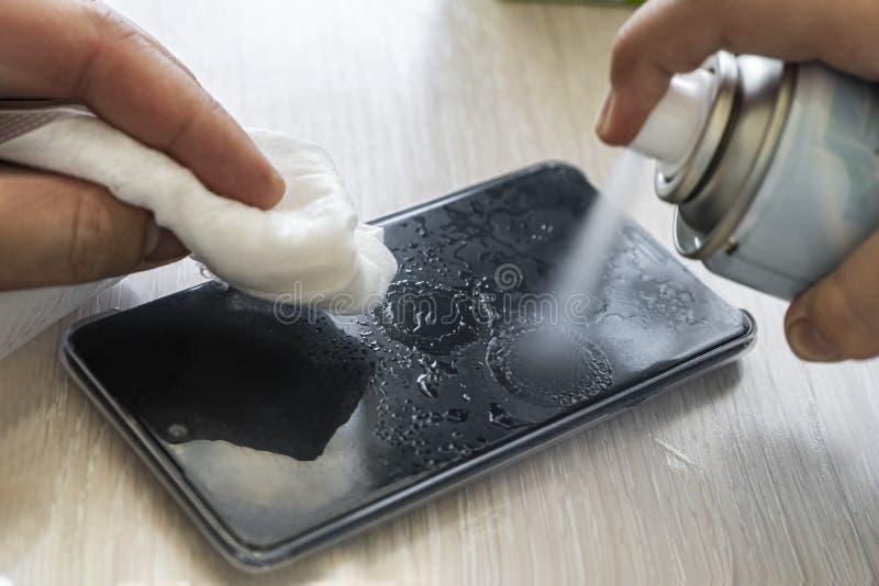 Man Wipes His Mobile Phone with a Rag. Disinfecting Alcohol Solution