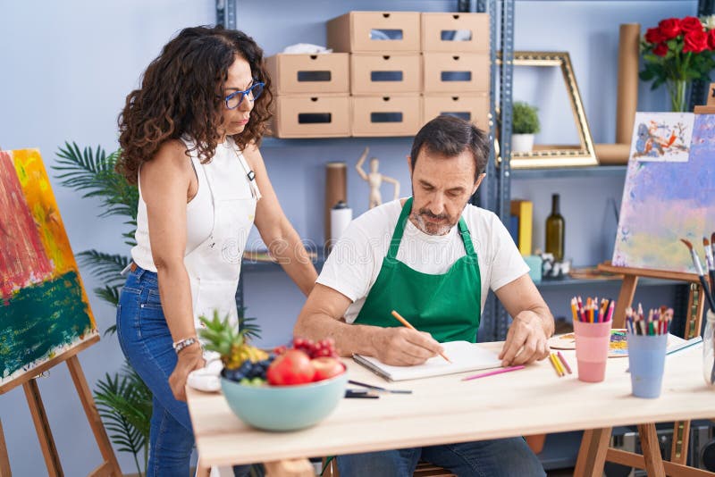 Man and Woman Artists Drawing on Notebook at Art Studio Stock Image