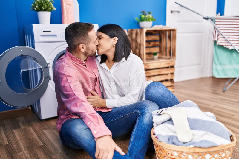 Man And Woman Couple Washing Clothes Hugging Each Other And Kissing At Laundry Room Stock Image