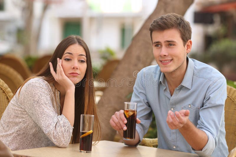 Man and woman dating but she is boring while he speaks royalty free stock image Man and woman dating but she is boring while he speaks royalty free stock image