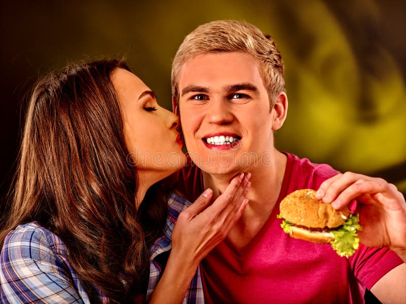 Man and woman eating big sandwich.