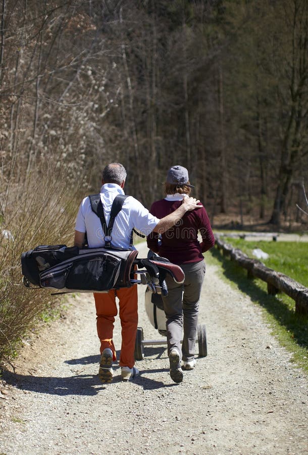 Man and woman golfer walking on a golf course