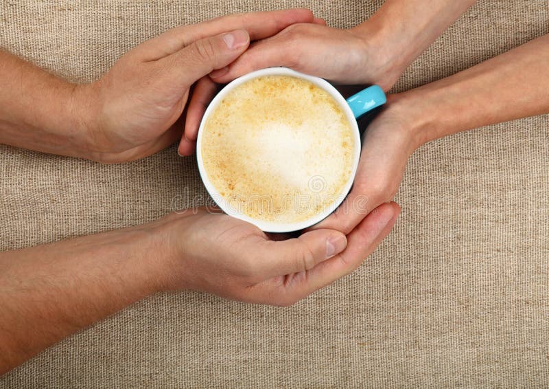 Man and woman hands hold full latte coffee cup