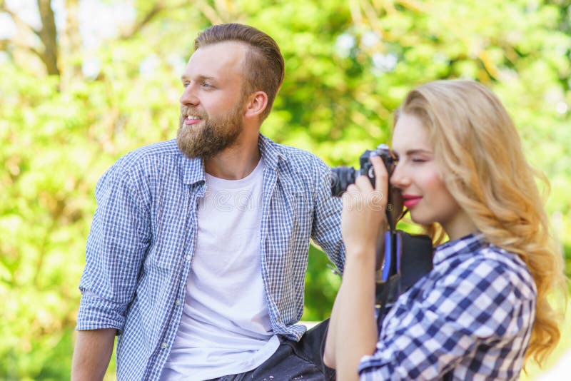 Man and woman having date outdoor. Girl wit a photo camera and her boyfriend. stock photo Man and woman having date outdoor. Girl wit a photo camera and her boyfriend. stock photo