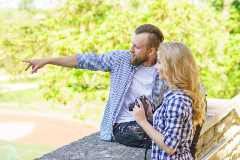 Man and woman having date outdoor. Girl wit a photo camera and her boyfriend. royalty free stock photos Man and woman having date outdoor. Girl wit a photo camera and her boyfriend. royalty free stock photos