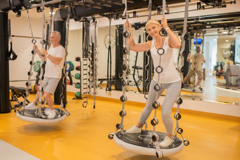 A Man and a Woman Having a Workout in Gym on Gym Machines Stock Photo