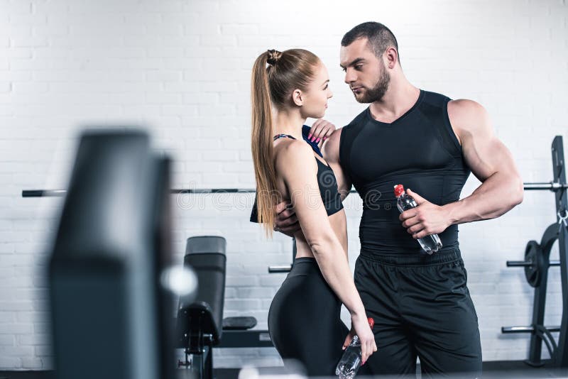 Man In Woman Holding Bottles Of Water And Hugging In Gym Stock Image Image Of Training