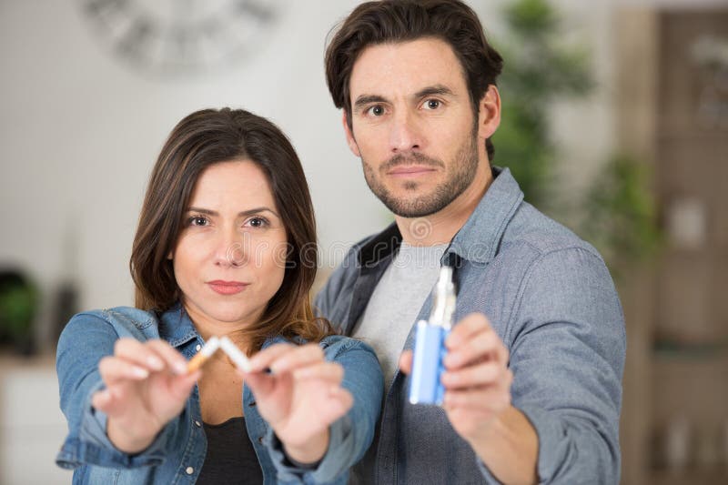 man and woman holding broken cigarette and vaping machine