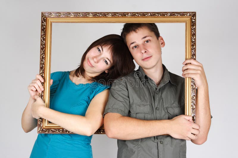 Man and woman holding frame and standing inside it