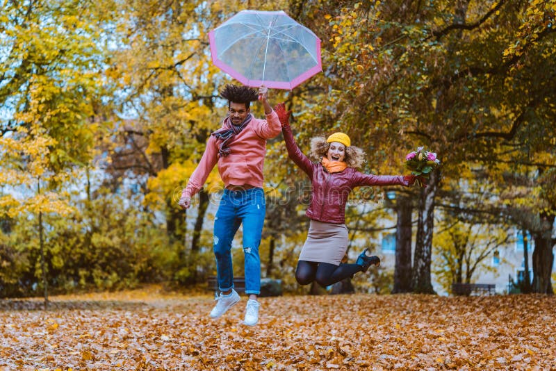 Man And Woman Jumping Joyfully In The Autumn Park Stock Photo Image