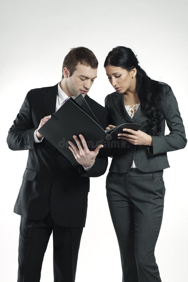 Businessman and businesswoman carefully studying portfolio. Standing file folder stock images, royalty-free photos and pictures