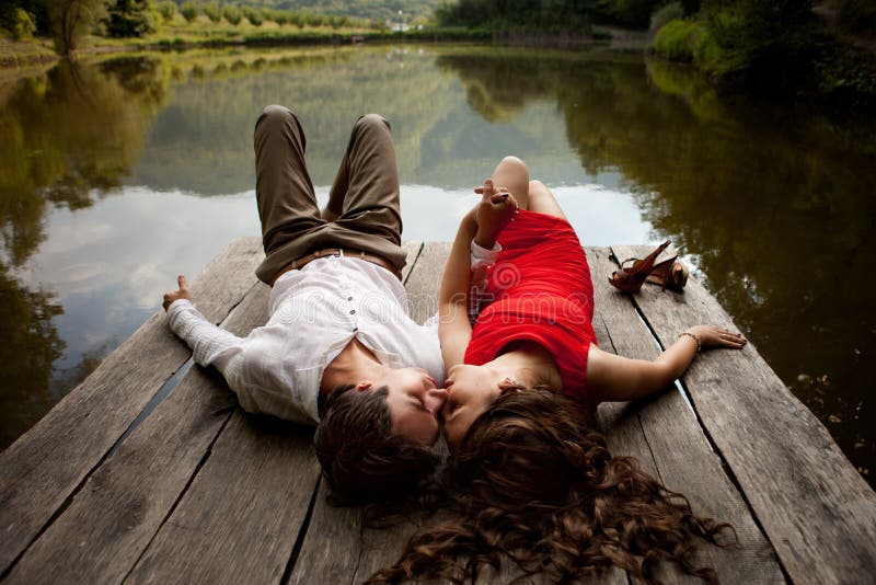 Man and woman are looking at each other on a wooden bridge over