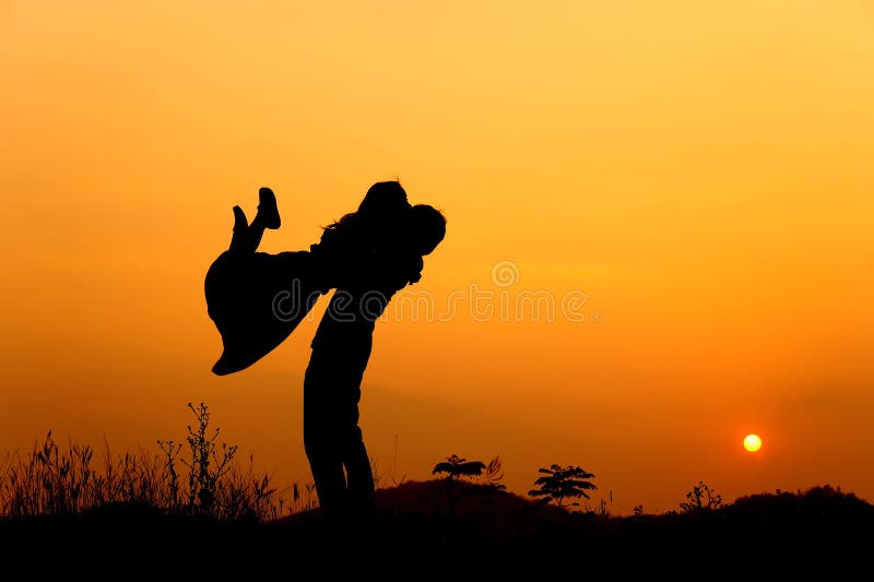Man and Woman love silhouette in sunset stock photo