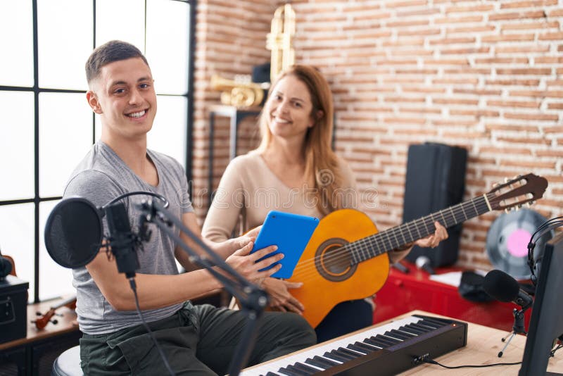 Man and Woman Musicians Having Classic Guitar Lesson Using Touchpad at Music Studio Stock Photo