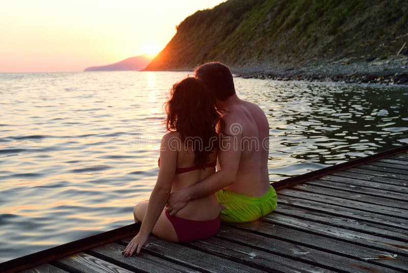 Man and woman on a pier at sunset royalty free stock image