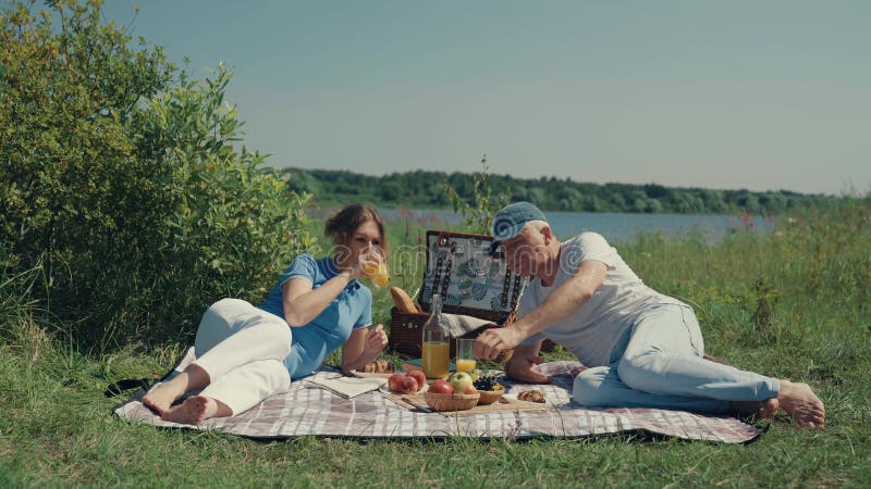 A man and a woman relax on a picnic in the summer.