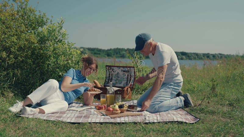 A man and a woman relax on a picnic in the summer.