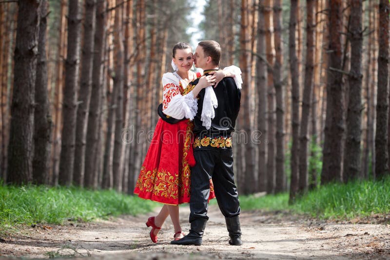 Young smiling woman in traditional russian clothes stands on a