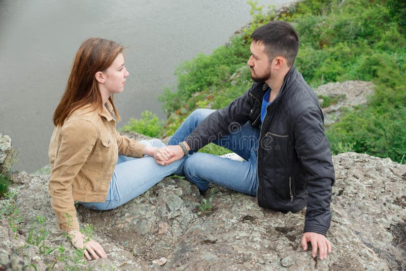 A man and a woman are sitting face to face on a stone platform stock photography A man and a woman are sitting face to face on a stone platform stock photography
