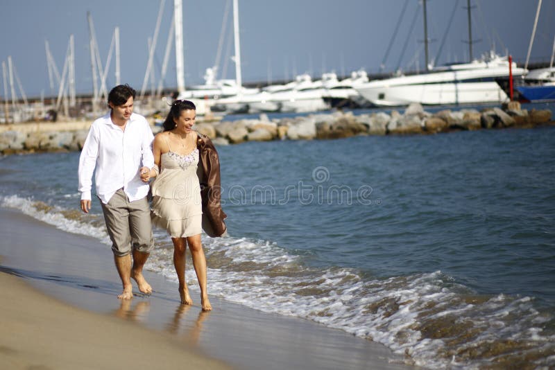 Man and woman walking on beach stock images