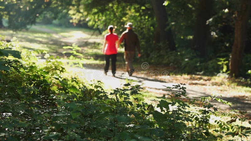 Man and woman walking outdoors on sunny day