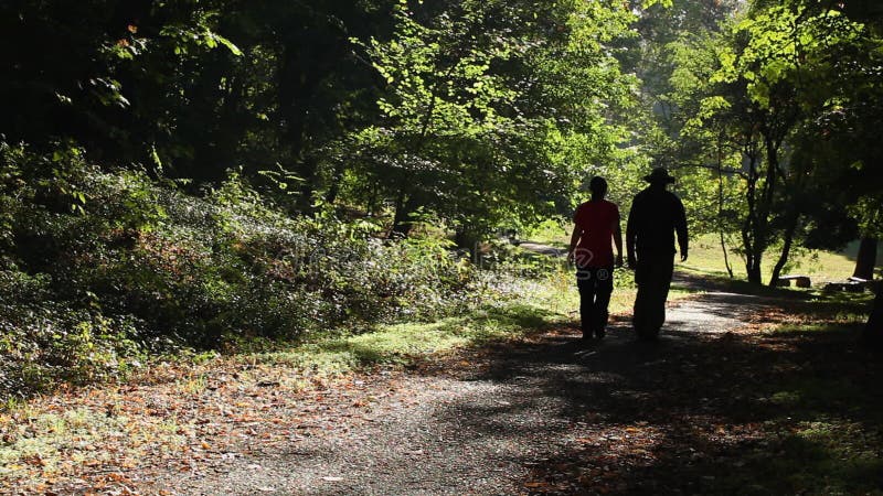 Man and woman walking outdoors on sunny day