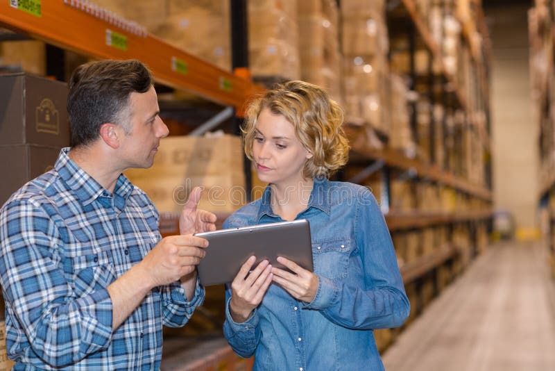 Man and woman worker with tablet at warehouse royalty free stock image Man and woman worker with tablet at warehouse royalty free stock image