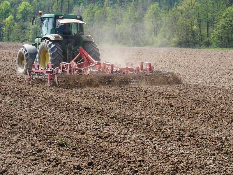 Man work with tractor and harrow