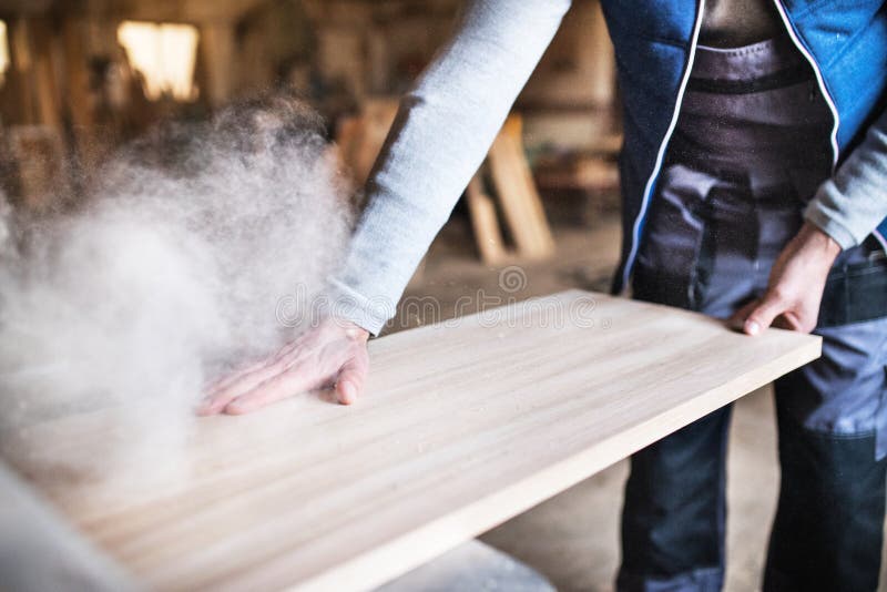 An unrecognizable man worker in the carpentry workshop, working with wood. An unrecognizable man worker in the carpentry workshop, working with wood.