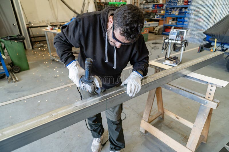 Man worker cutting metal profile with angle grinder stock image