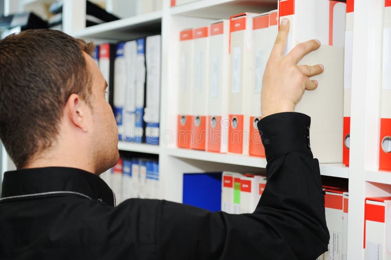 Man working at office putting folders