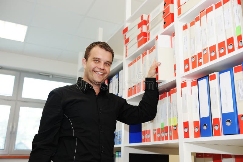 Man working at office putting folders together