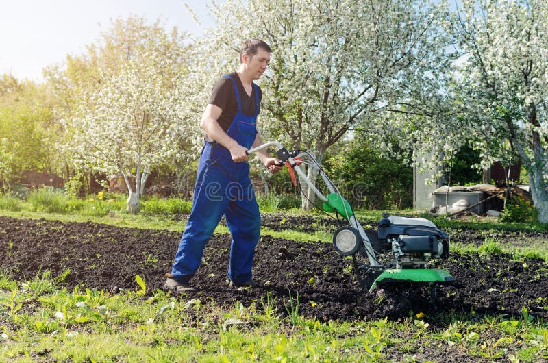 Man Working In The Spring Garden With Tiller Machine Stock Image